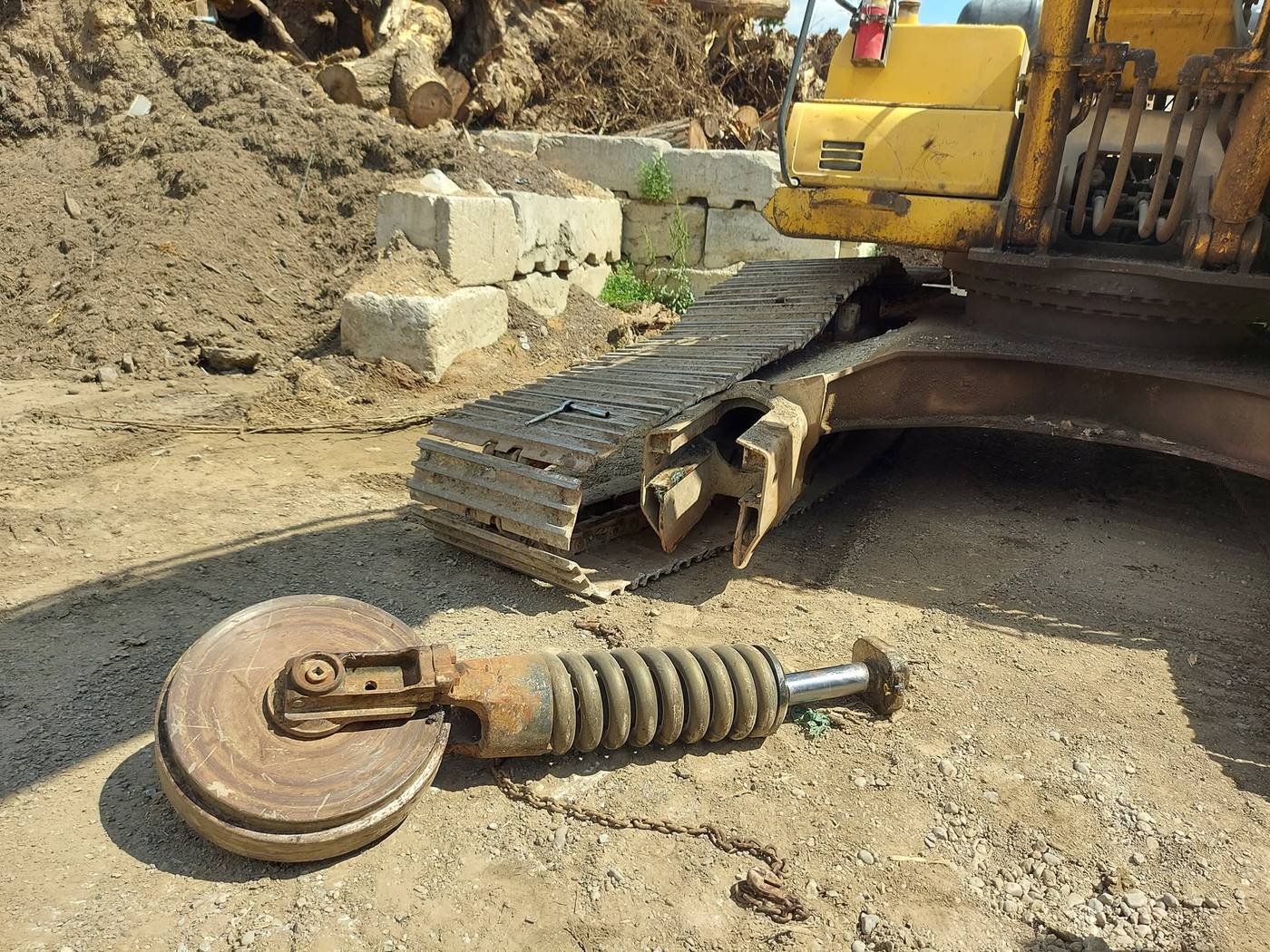 Excavator front idler and recoil spring removed on site for repair